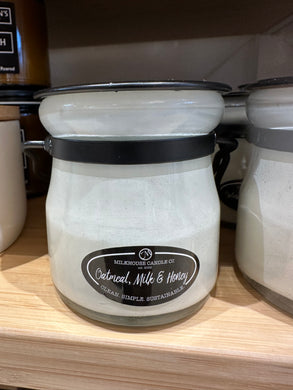Oatmeal, milk, and honey 5 oz candle in white jar with black accents. 