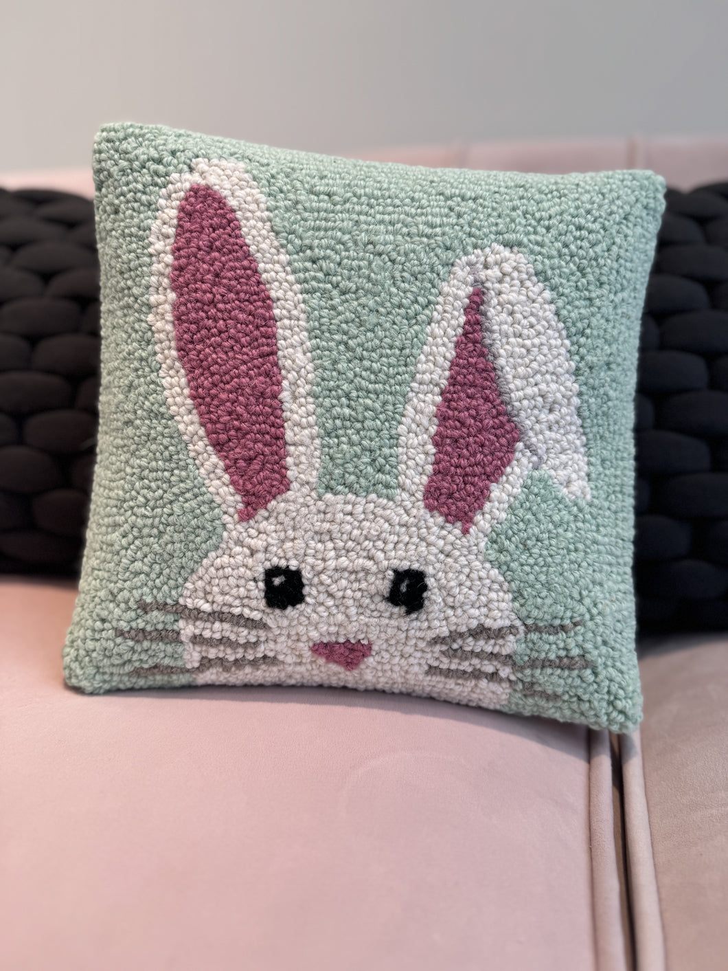 Square throw pillow featuring a hand-hooked wool bunny design on soft velvet backing.