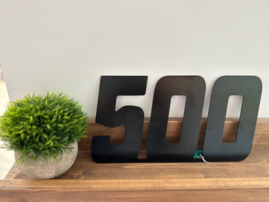 black 500 metal sign sitting on shelf
