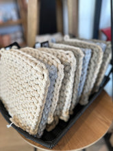 Load image into Gallery viewer, A knitted pot holder, made of thick cotton yarn in ivory, olive, or grey. It has a loop at the top for hanging.
