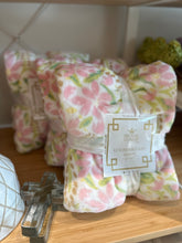Load image into Gallery viewer, Cozy throw blankets on shelf.  50x60 white with pink and green spring flower pattern. 
