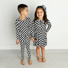 Load image into Gallery viewer, Little girl with checkered dress and checkered bow and little boy with checkered 2 piece pajamas. 
