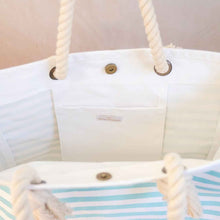 Load image into Gallery viewer, Nautical beach tote in blue/white stripes.  Inside view shows interior pocket and magnetic closure. 
