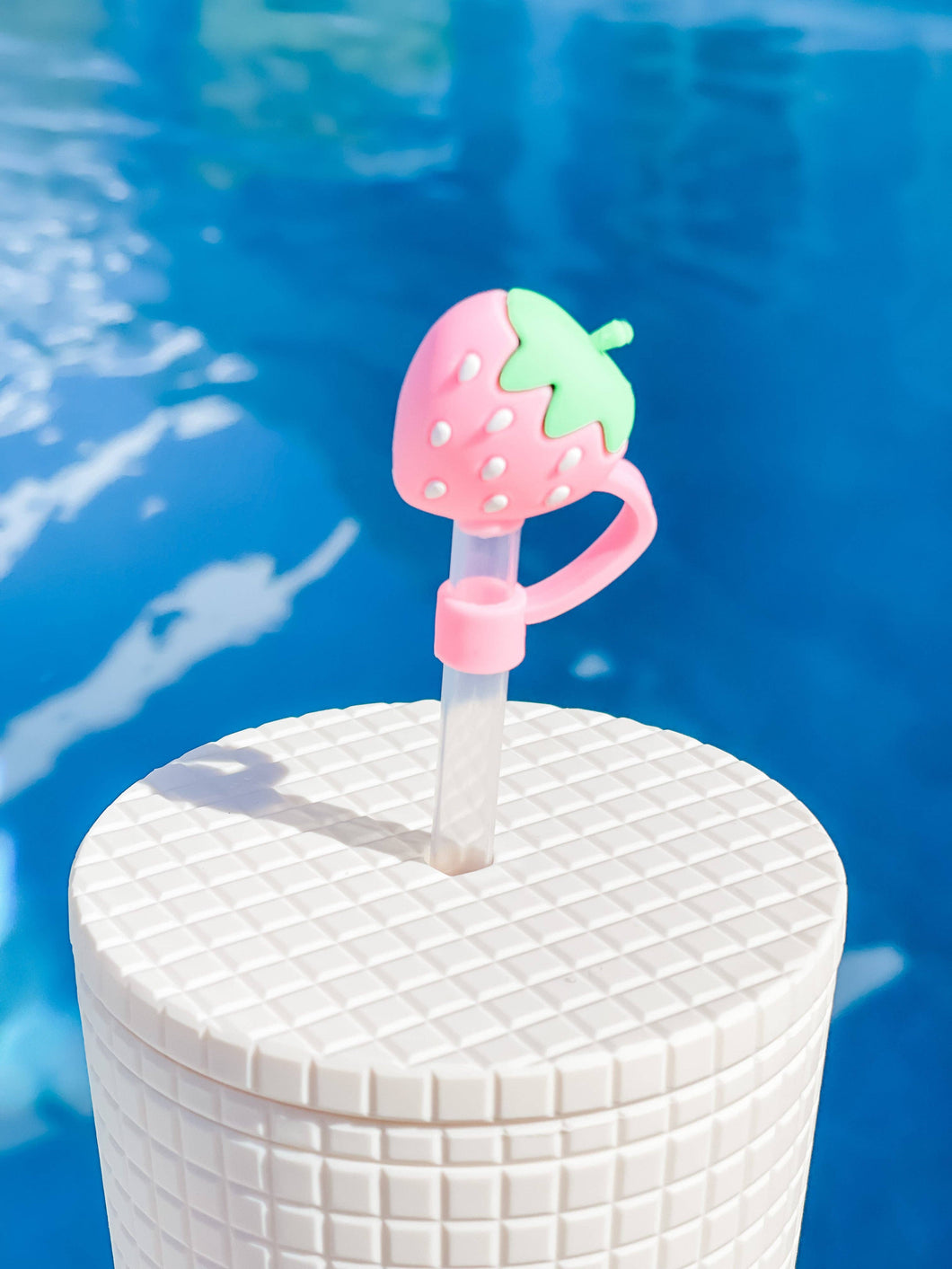 A cute and colorful pink strawberry straw topper, perfect for adding a touch of fun to any drink.