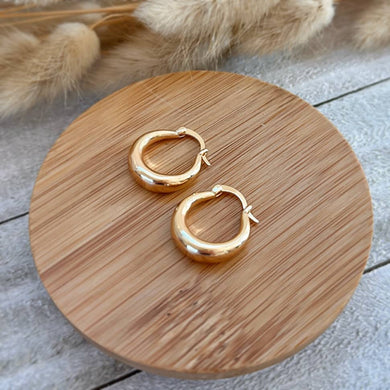 Bold gold plated hoop earrings with a chunky, round silhouette.