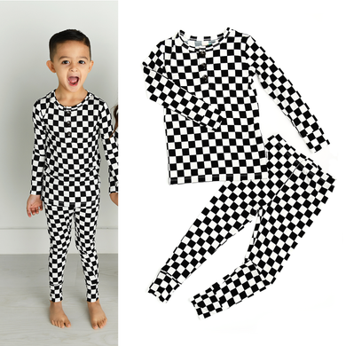 Two piece black and white checkered pajamas on little boy and shown by themselves.  Has 3 buttons at top.  